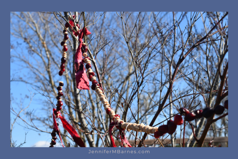 Skyview of a bare tree holding one popcorn and cranberry garland.